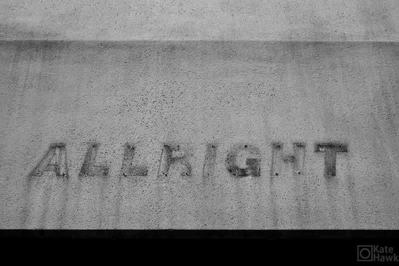 The letters ALLRIGHT stained on concrete